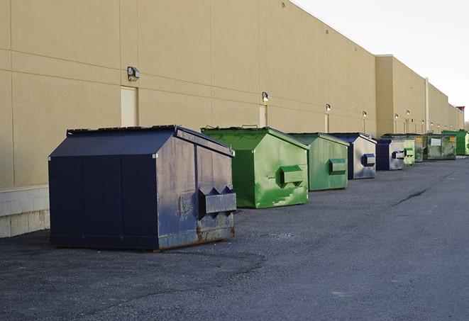 a construction worker moves construction materials near a dumpster in Berwick